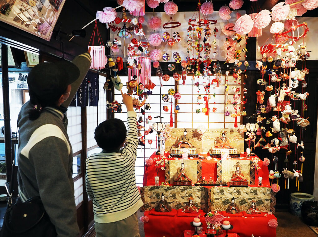 ひな人形とつるしびなを見学する親子