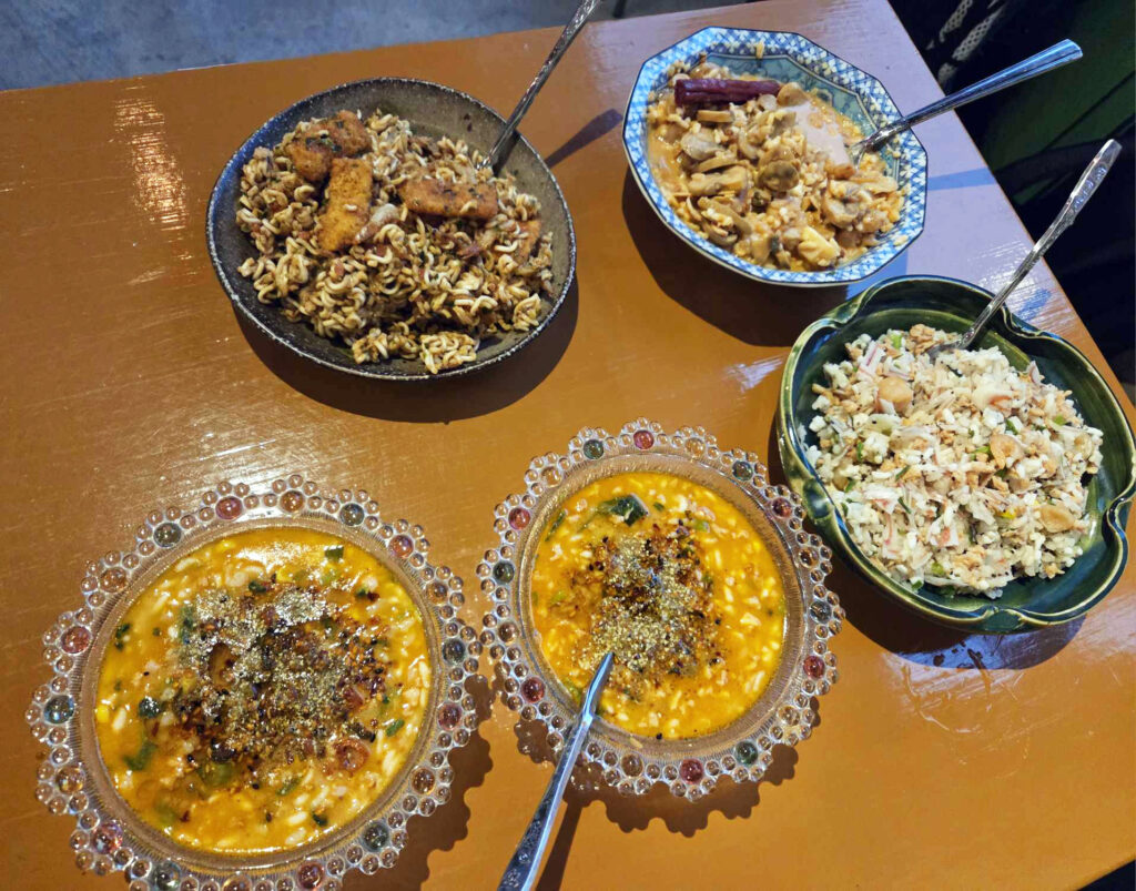 交流会で地守さんが披露した大会中の食事。左上から時計回りにカツ焼きそば、海鮮トマトリゾット、蟹チャーハン、坦々スープライスで、一食分の乾燥重量約125g=500kcal。写真提供:地守さん