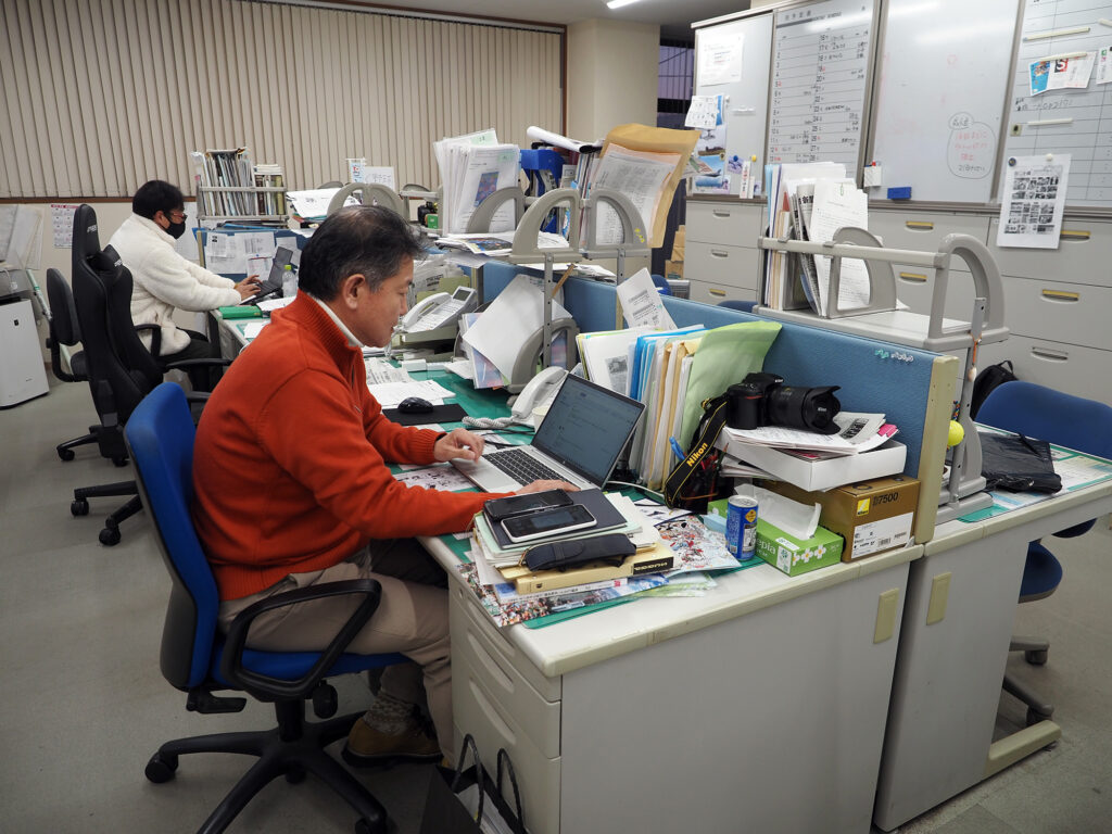 房日新聞社内で仕事をこなす斎藤さん
